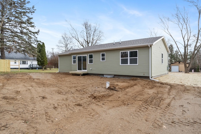 back of house featuring a garage and an outdoor structure