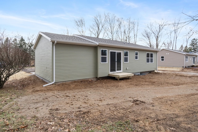 back of house with a shingled roof