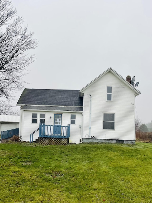 back of property with a wooden deck and a lawn