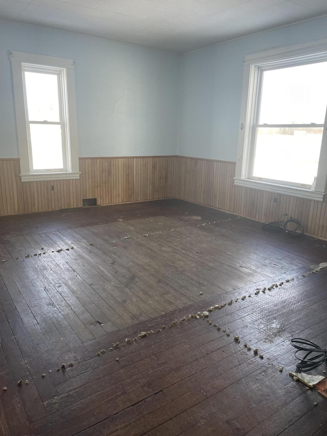 spare room featuring dark hardwood / wood-style floors and wood walls