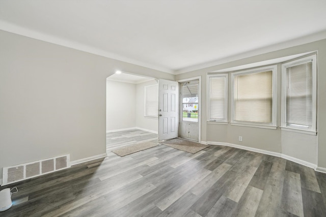 spare room with dark hardwood / wood-style floors and crown molding