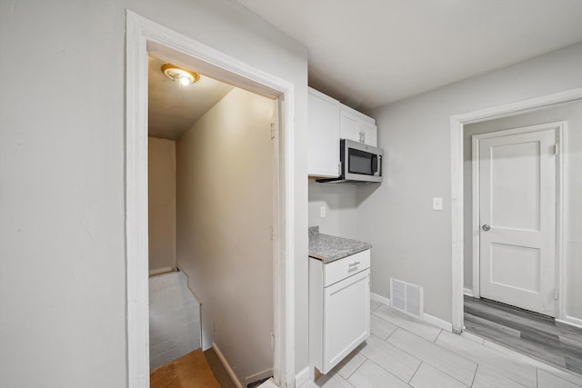 kitchen featuring white cabinets and light hardwood / wood-style flooring