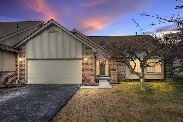 view of front of home with aphalt driveway, an attached garage, brick siding, a shingled roof, and a front lawn