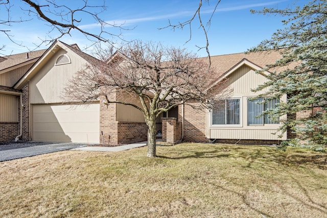 view of front of house featuring aphalt driveway, a garage, brick siding, roof with shingles, and a front yard