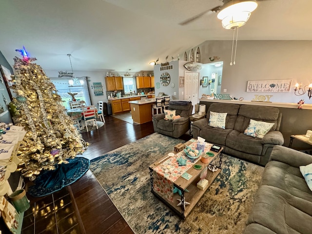 living room with lofted ceiling, ceiling fan, and dark wood-type flooring