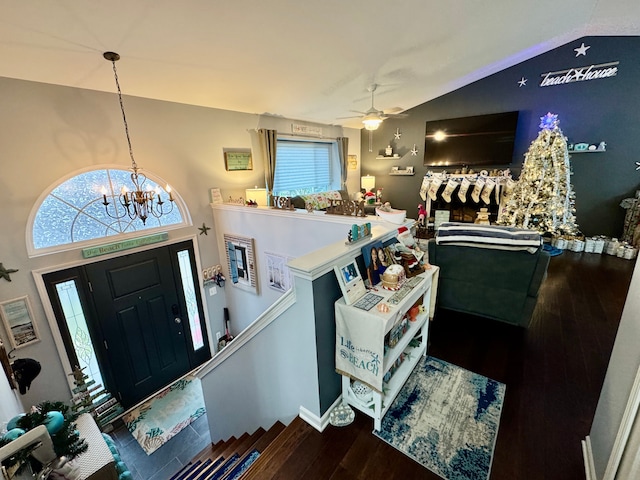 entryway featuring ceiling fan with notable chandelier, wood-type flooring, and lofted ceiling