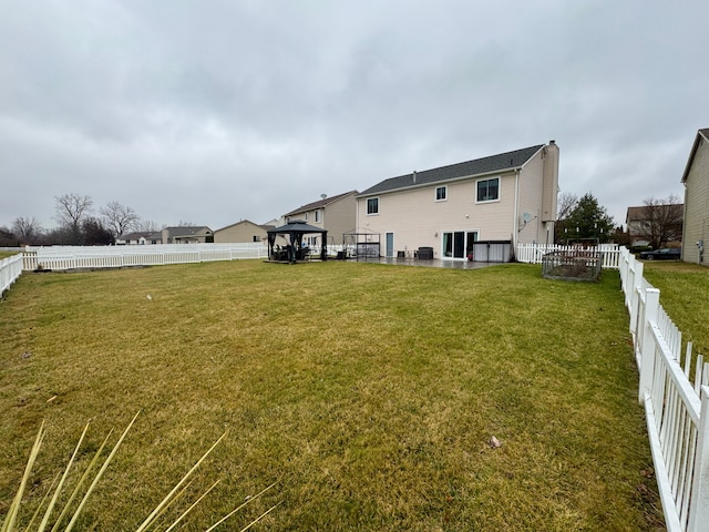 back of house featuring a gazebo and a lawn