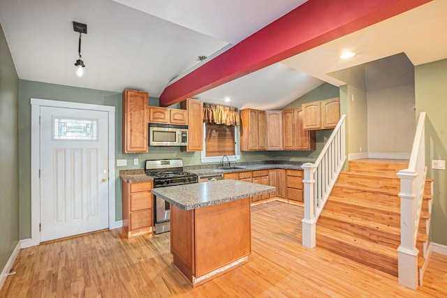 kitchen featuring decorative light fixtures, sink, a center island, light hardwood / wood-style floors, and stainless steel appliances