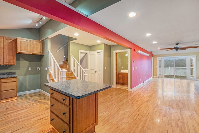 kitchen with ceiling fan, lofted ceiling, track lighting, and light wood-type flooring