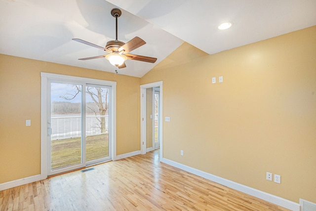 spare room featuring vaulted ceiling, ceiling fan, and light hardwood / wood-style floors