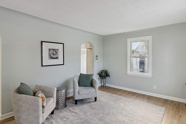 living area with a textured ceiling and hardwood / wood-style flooring