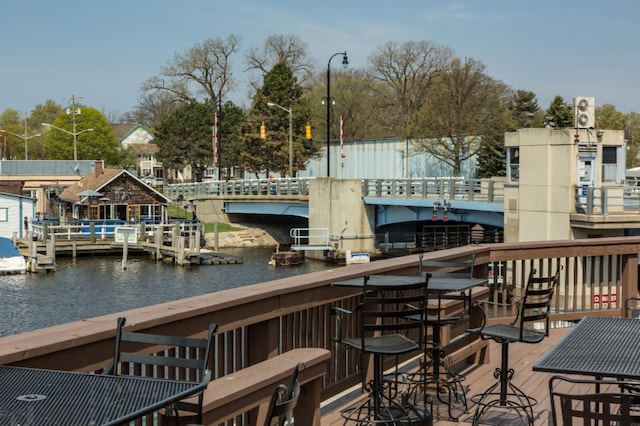 exterior space featuring a deck with water view and an outdoor bar