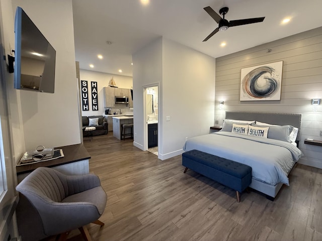 bedroom with hardwood / wood-style flooring, ceiling fan, and connected bathroom