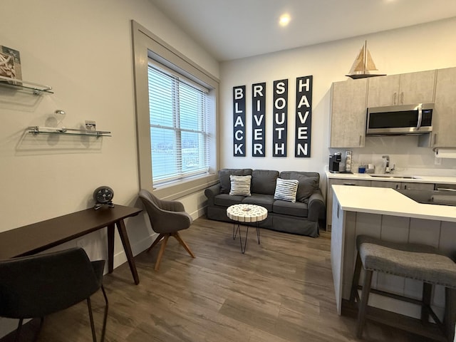 kitchen with dark hardwood / wood-style floors, kitchen peninsula, sink, and a breakfast bar area