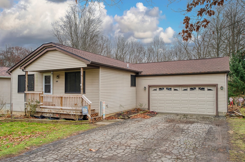 ranch-style home with a porch and a garage