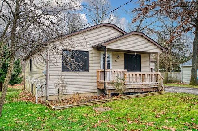 bungalow with covered porch and a front lawn