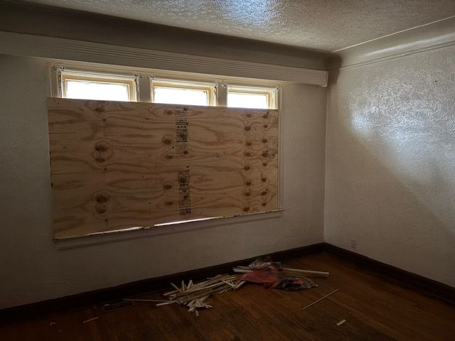 empty room with a textured ceiling, dark hardwood / wood-style floors, and plenty of natural light