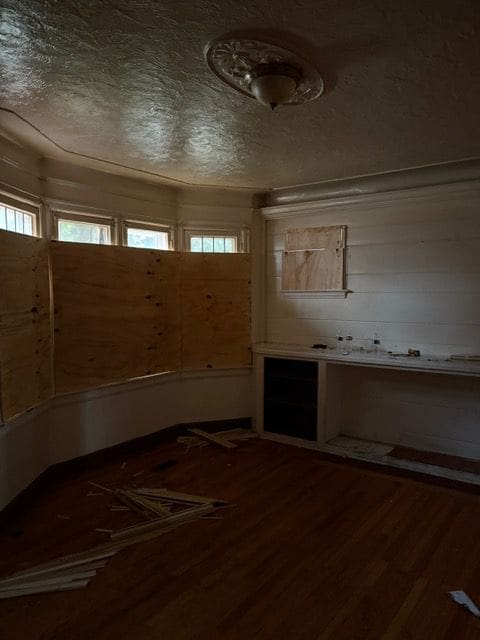 spare room with a textured ceiling and hardwood / wood-style flooring