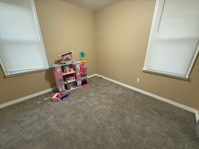 recreation room featuring dark carpet