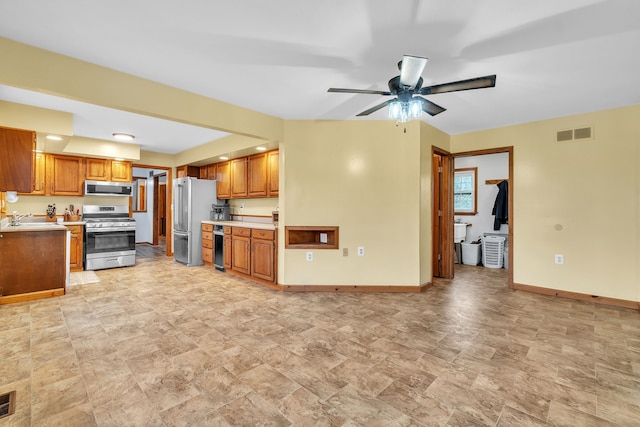 kitchen with appliances with stainless steel finishes, ceiling fan, and sink