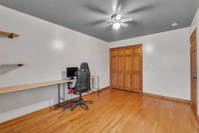 office space with ceiling fan, built in desk, and light wood-type flooring