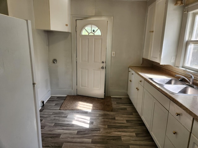 kitchen with white cabinets, dark hardwood / wood-style flooring, white refrigerator, and sink