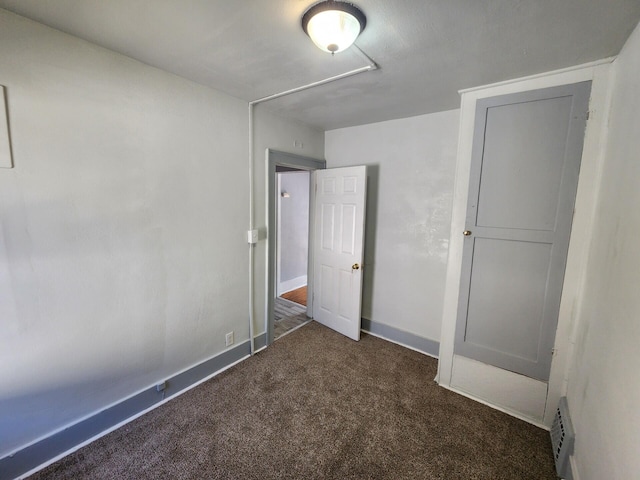 unfurnished bedroom with dark carpet