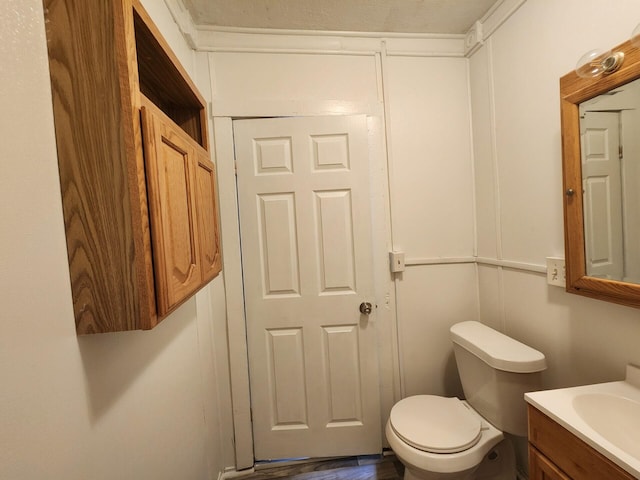 bathroom featuring vanity, hardwood / wood-style flooring, and toilet