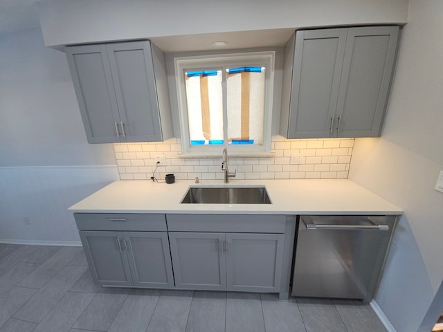 kitchen featuring gray cabinets, dishwasher, and sink