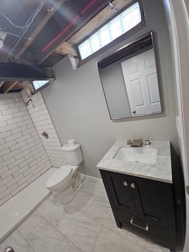 bathroom featuring a shower, vanity, and toilet