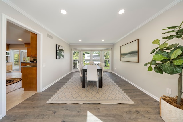 dining space featuring dark wood-type flooring, a healthy amount of sunlight, french doors, and ornamental molding