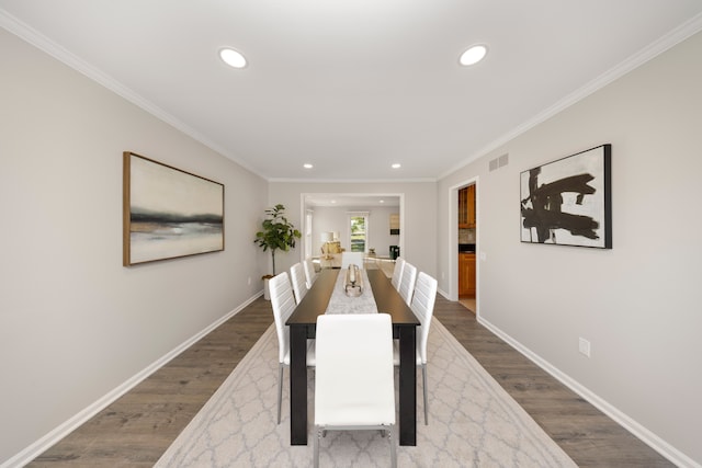 dining area featuring hardwood / wood-style floors and crown molding