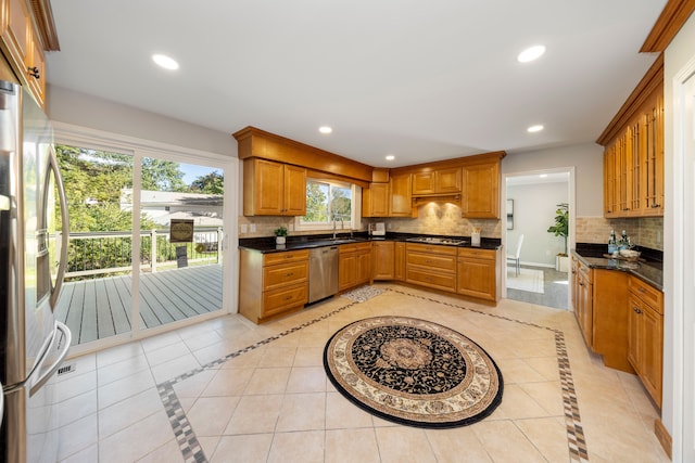 kitchen with tasteful backsplash, sink, light tile patterned floors, and stainless steel appliances