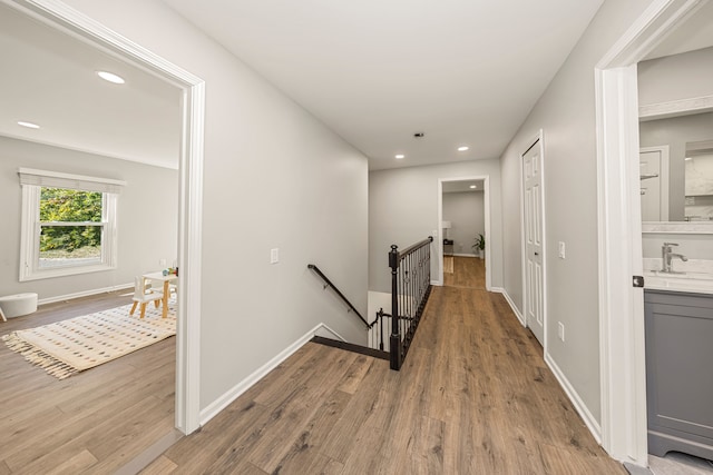 hallway with sink and light hardwood / wood-style floors