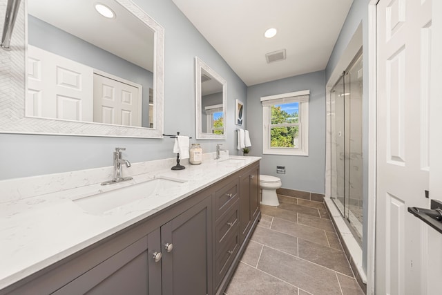 bathroom featuring tile patterned flooring, vanity, toilet, and a shower with shower door