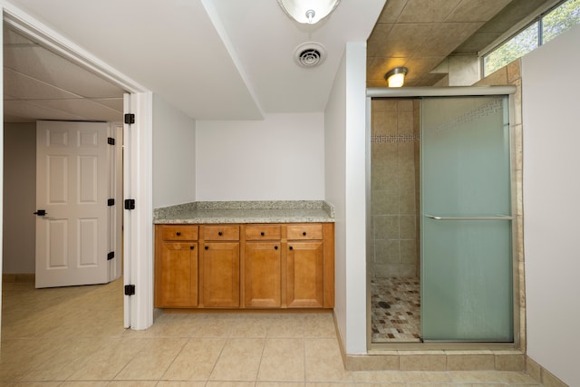 bathroom featuring tile patterned floors, vanity, and a shower with door