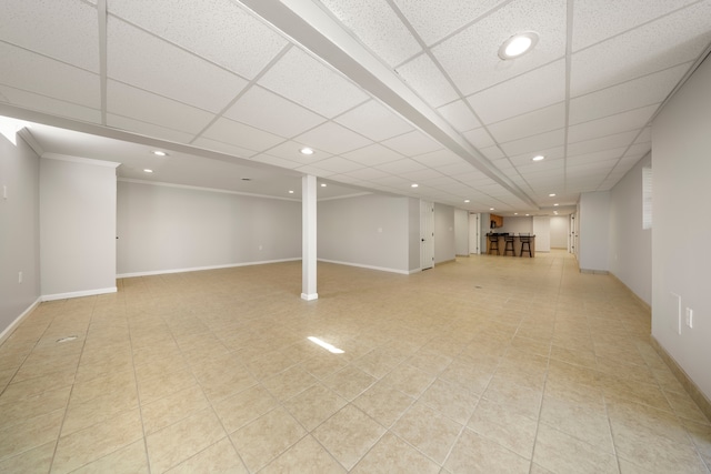 basement with a paneled ceiling and ornamental molding