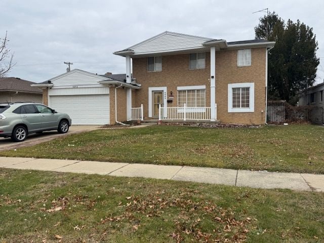 view of front of property with a front lawn and a garage