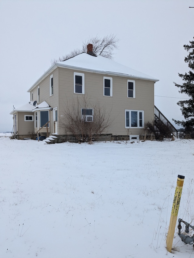 view of snow covered back of property