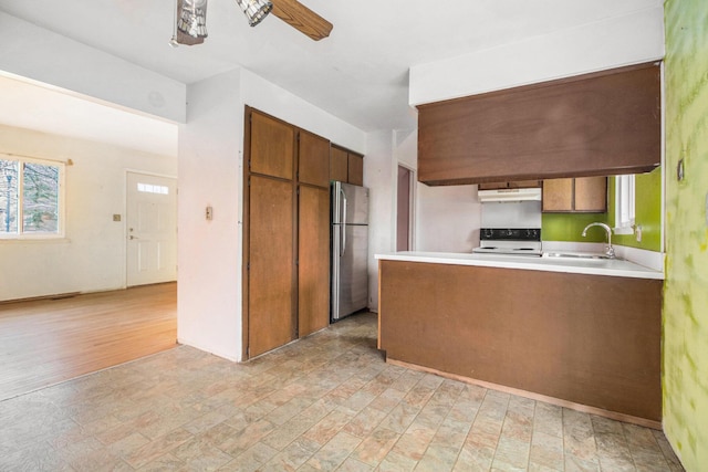 kitchen featuring stainless steel refrigerator, ceiling fan, sink, light hardwood / wood-style flooring, and white range oven