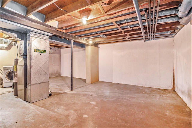 basement featuring washer / dryer and heating unit