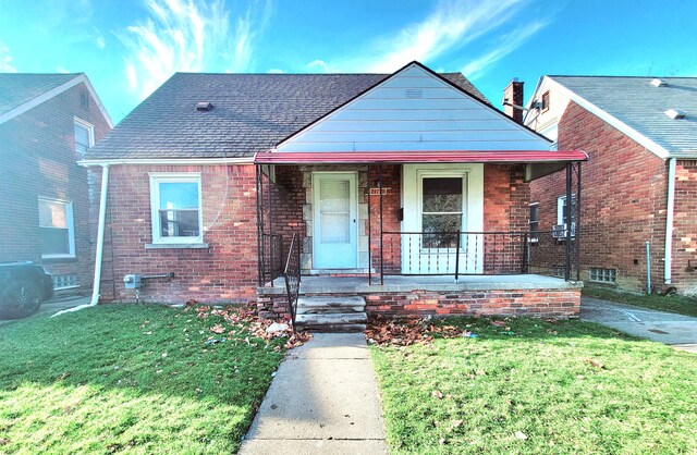 bungalow-style house featuring covered porch and a front lawn