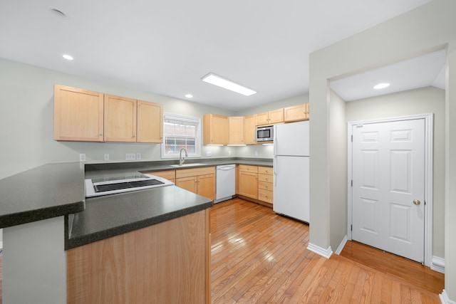 kitchen with kitchen peninsula, white appliances, sink, light brown cabinets, and light hardwood / wood-style flooring