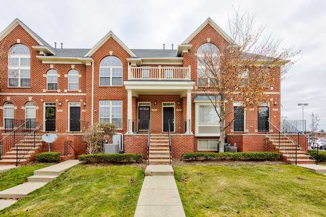 view of property featuring a front yard and a balcony