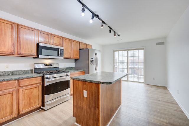 kitchen featuring a kitchen island, light wood-type flooring, appliances with stainless steel finishes, and track lighting