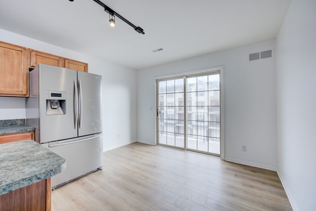 kitchen with stainless steel refrigerator with ice dispenser, light hardwood / wood-style floors, and track lighting