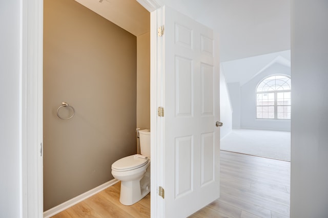 bathroom featuring toilet, vaulted ceiling, and hardwood / wood-style flooring