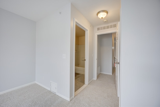 hallway featuring light carpet