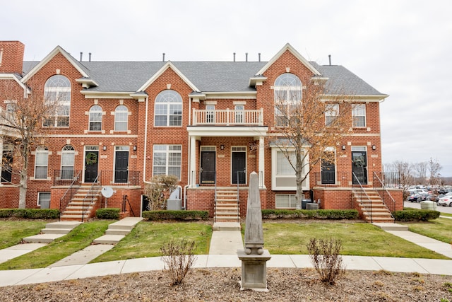 view of property with a front yard and a balcony