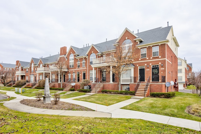 view of front facade with a front yard and a balcony